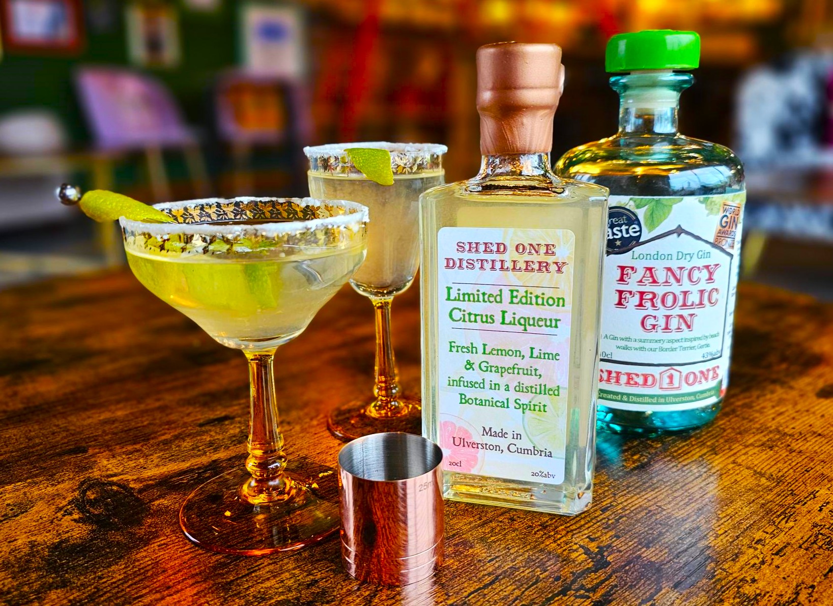A bottle of Liqueur, a bottle of gin, two glasses.  Gimlet Cocktail